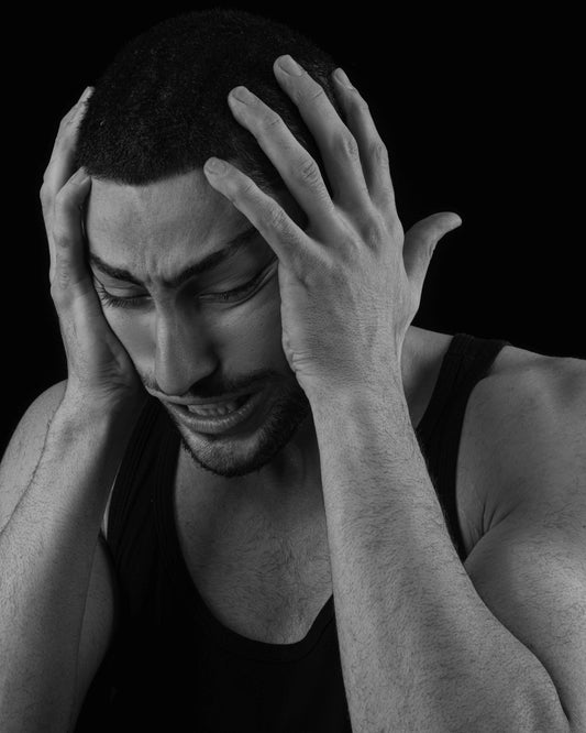 a man holding his hands to his head