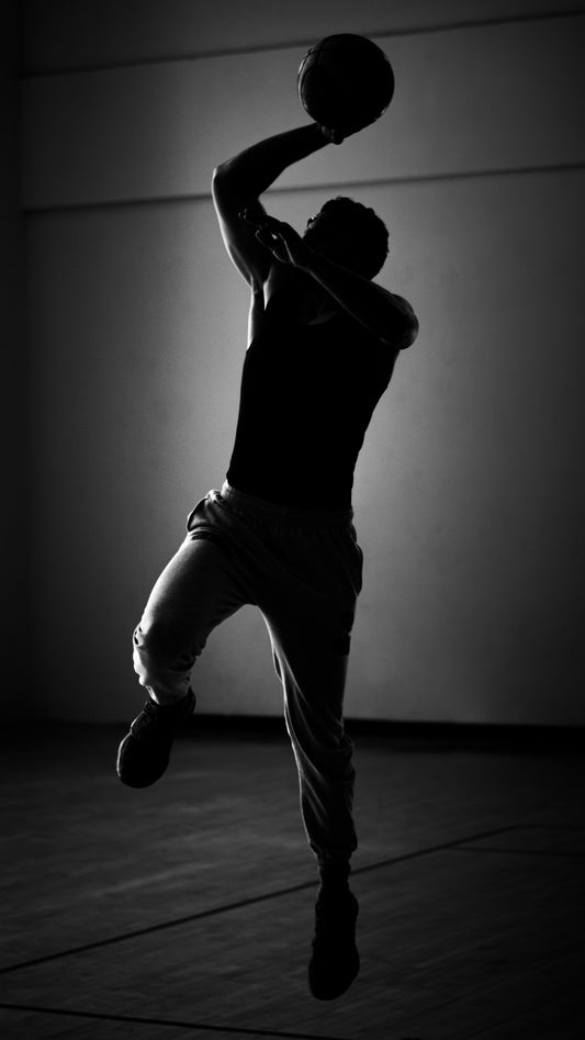 A man jumping in the air with a basketball in his hand