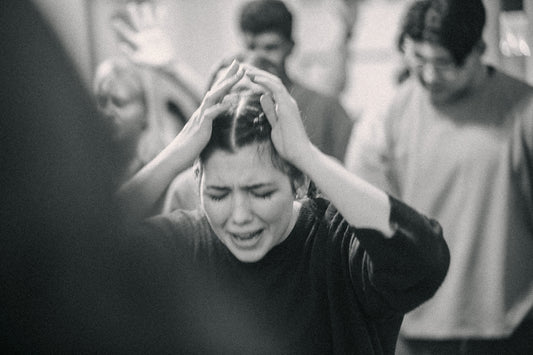A black and white photo of a woman covering her hair