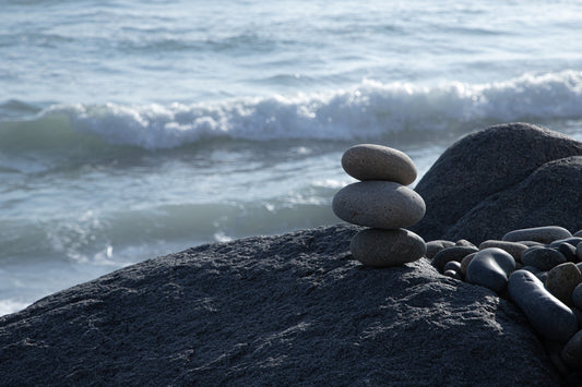 A pile of rocks sitting on top of a beach next to the ocean