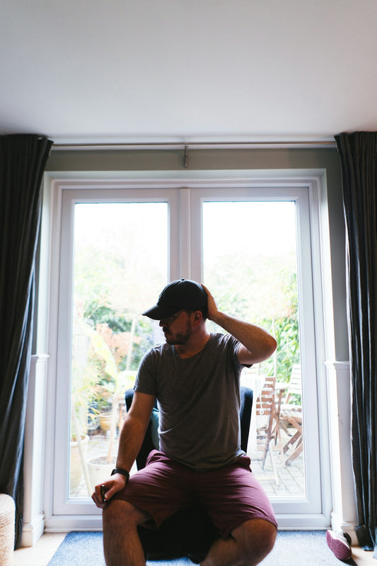 A man sitting on the floor in front of a window