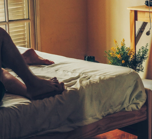 A person sitting on a bed in a room