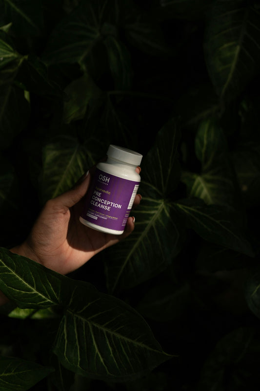 A hand holding a bottle of vitamin supplement
