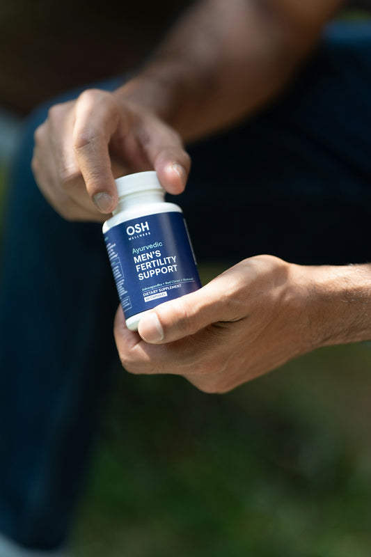 A man is holding a bottle of pills
