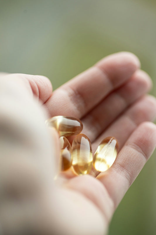 A person holding a handful of pills in their hand