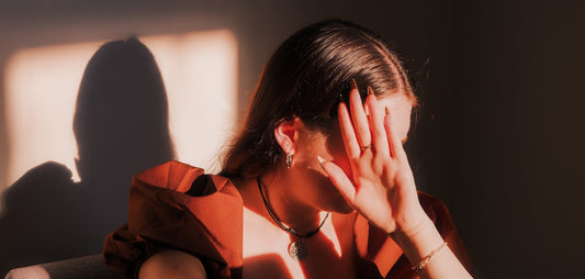 A woman sitting in a chair with her hands on her face