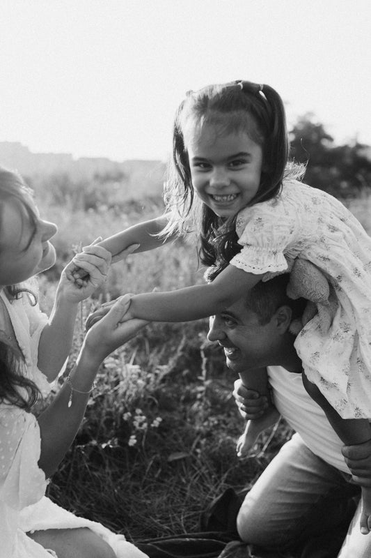 A man holding a little girl on his shoulders