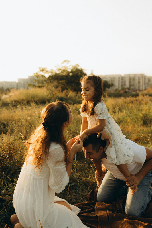 A man holding a little girl on his shoulders