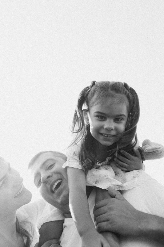 A black and white photo of a man holding a little girl