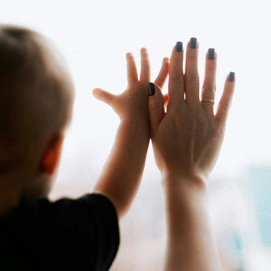 A woman holding her hands up in front of a window