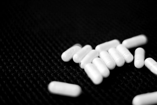 A pile of white pills sitting on top of a table
