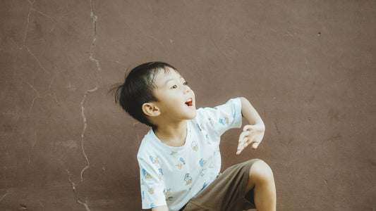 A happy child looks upward and smiles.
