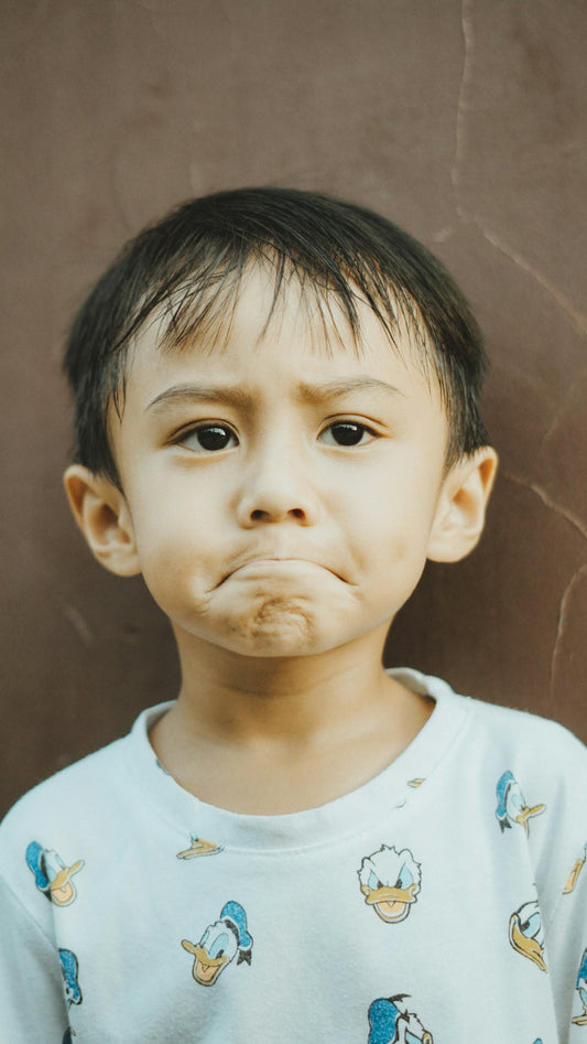 The young boy looks sad with a pouting expression.