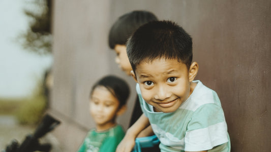 Three young boys are smiling at the camera.