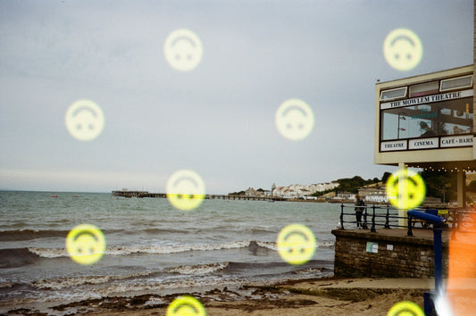 Beach scene with floating smiley faces