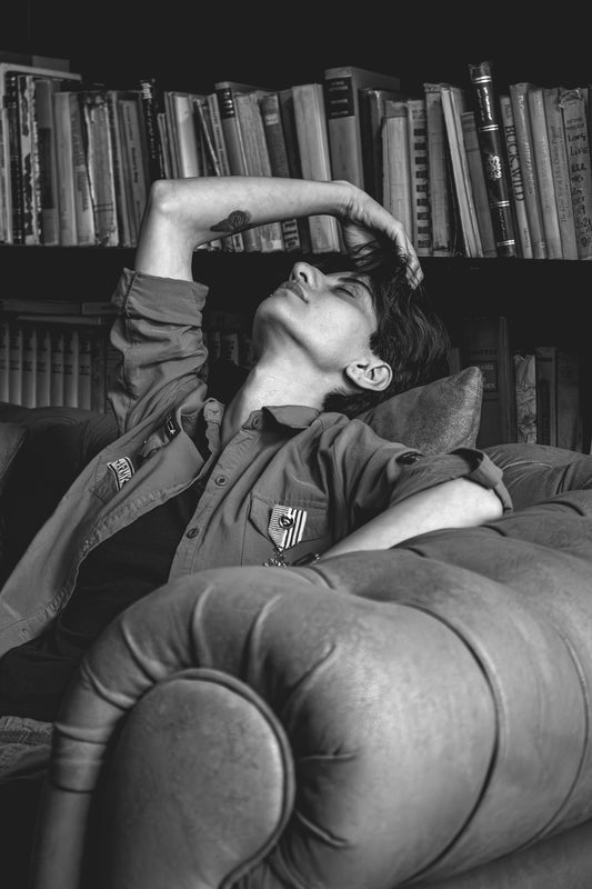 Woman resting on a couch with books behind her