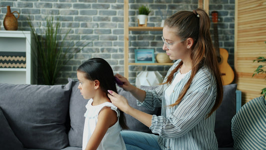Mother combs her daughter's long dark hair