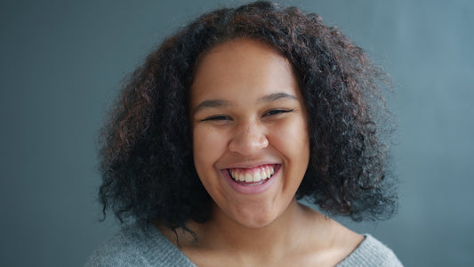 Young woman with curly hair laughing heartily