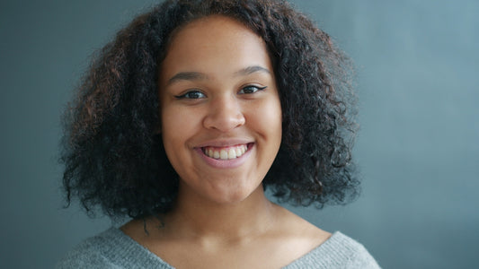 A young woman with curly hair smiling