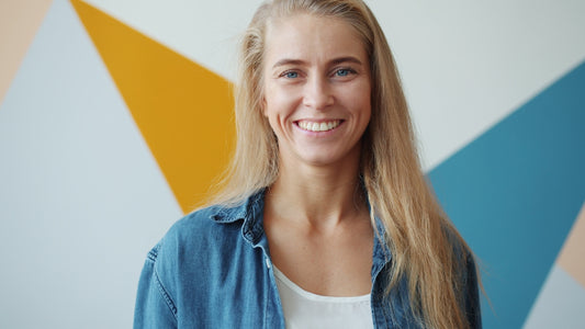 Blonde woman smiling in front of geometric wall