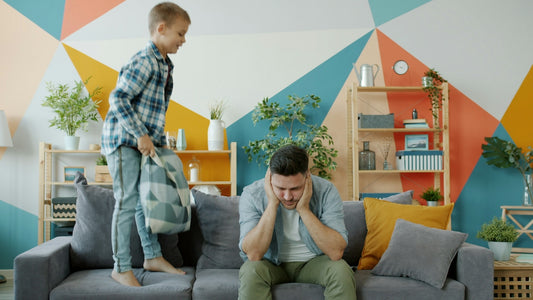 Father stressed as son jumps on couch