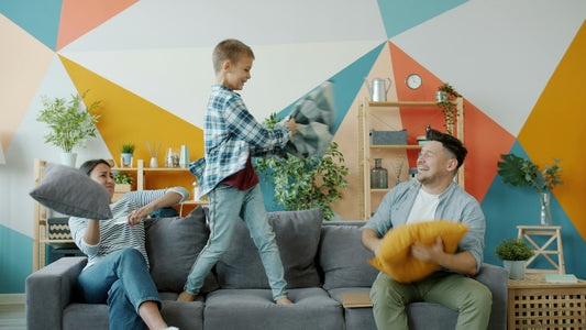 Family having a pillow fight on the couch