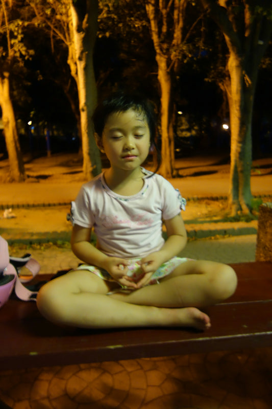 Young girl meditating outdoors at night