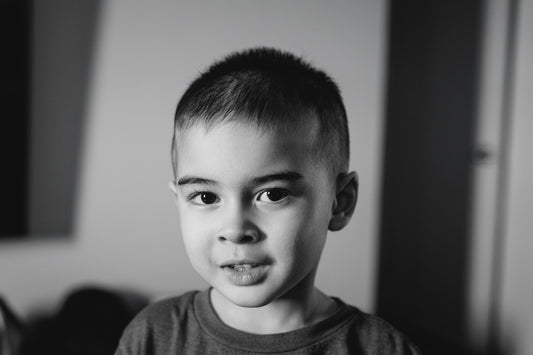A young boy with short hair looks at the camera.