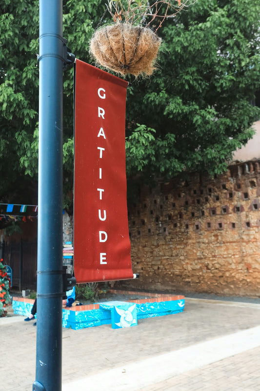A red banner with the word gratitude hangs outdoors.