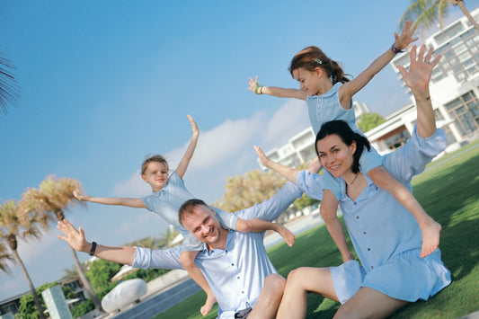 A happy family playing together outdoors on a sunny day.