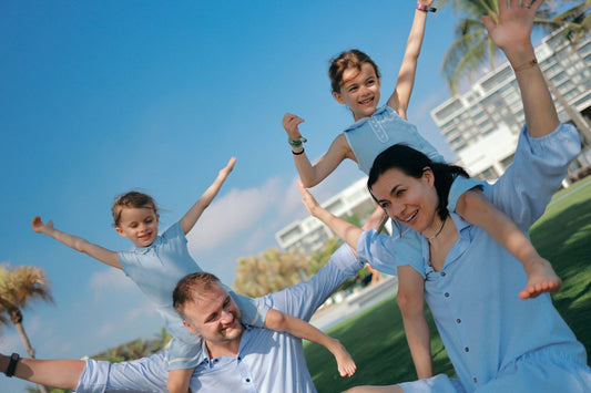 Family with arms outstretched on a sunny day.