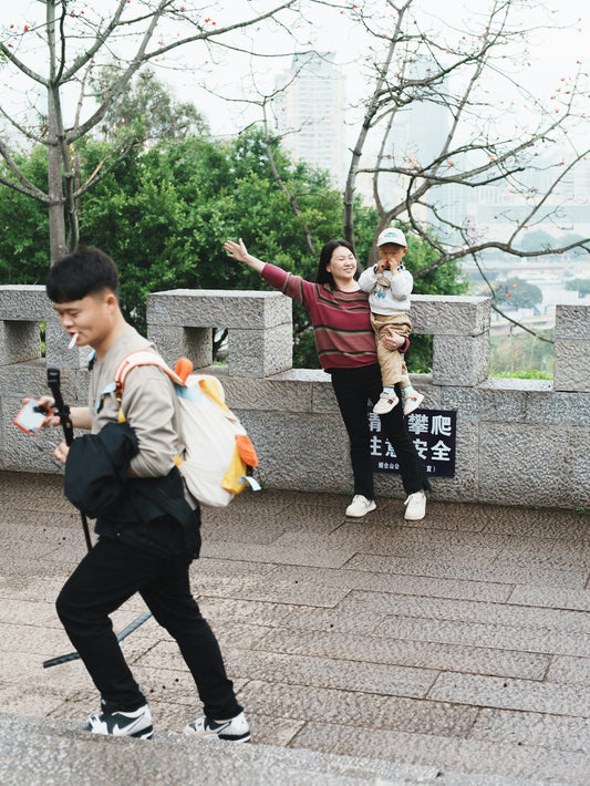 Family walking up stone stairs with city view.