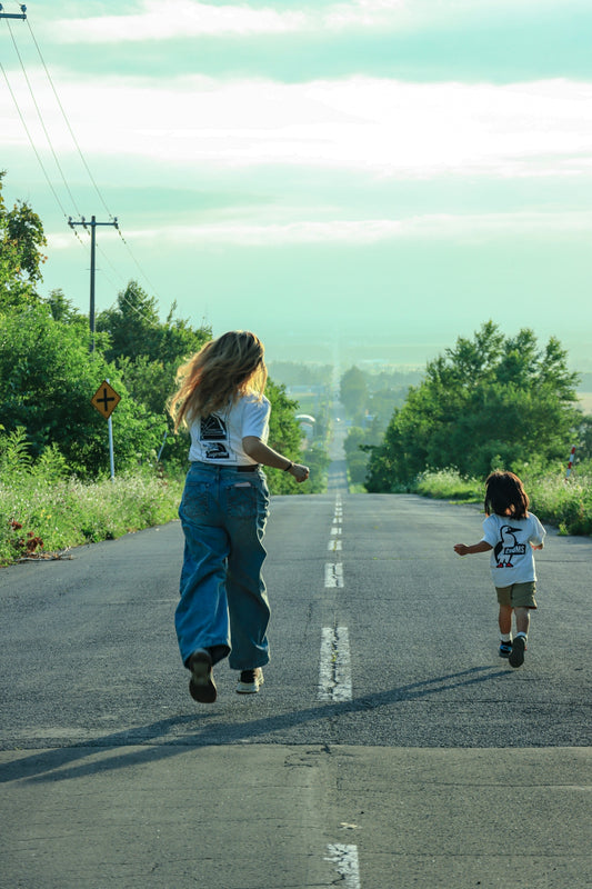 Woman and child running on an empty country road.